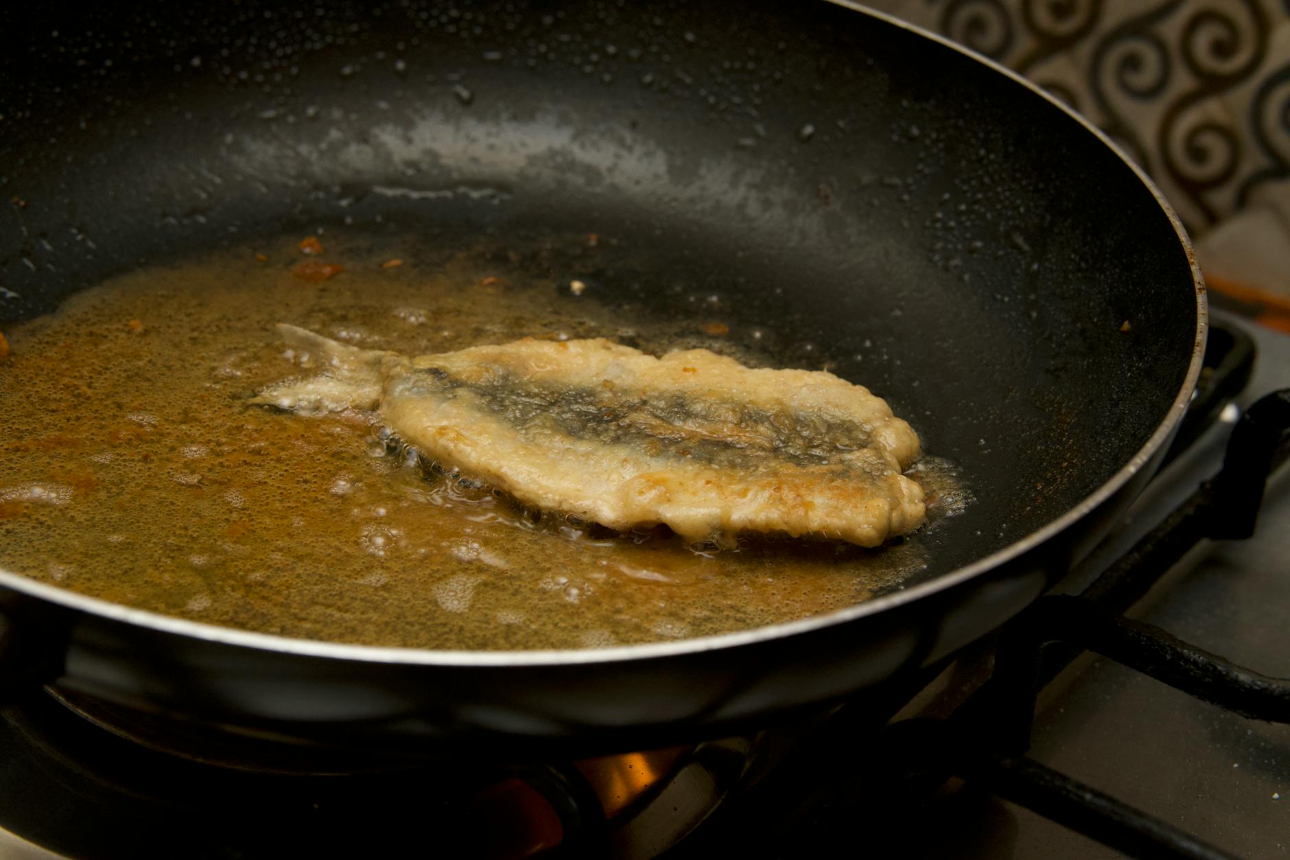Filet ryby smażony na maśle w patelni z gorącym tłuszczem
