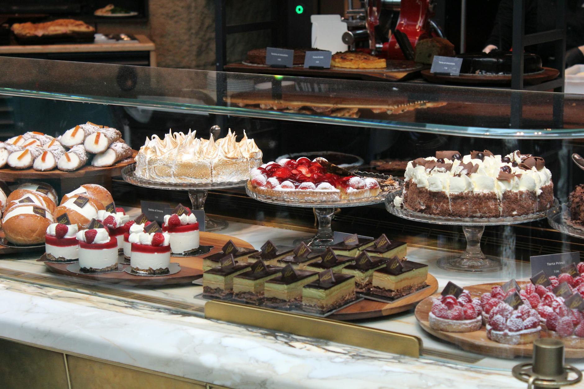 Eleganckie ciastka i torty wyłożone w ladzie cukierni