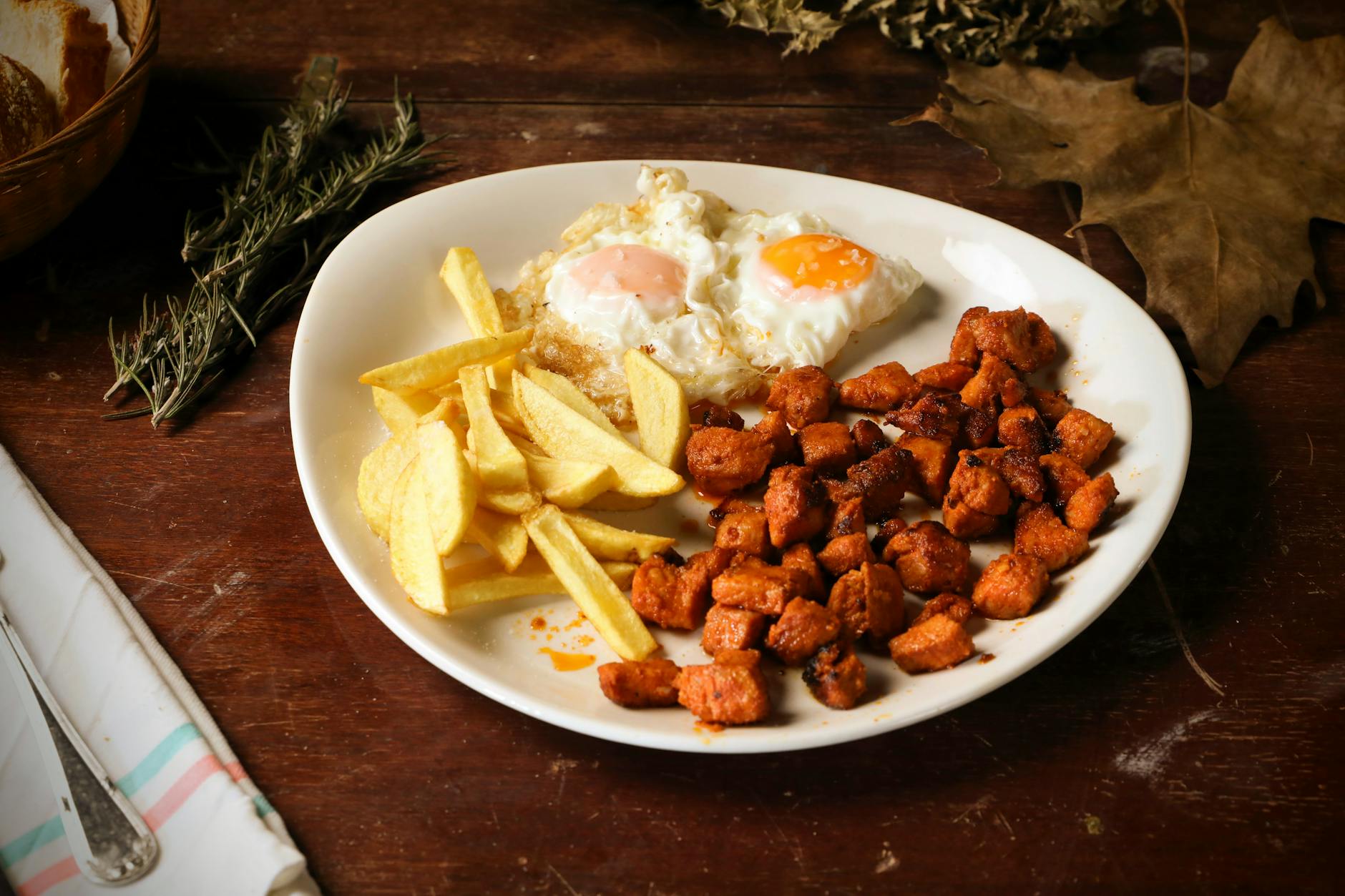Śniadaniowy talerz z jajkami sadzonymi, frytkami i chrupiącym mięsem