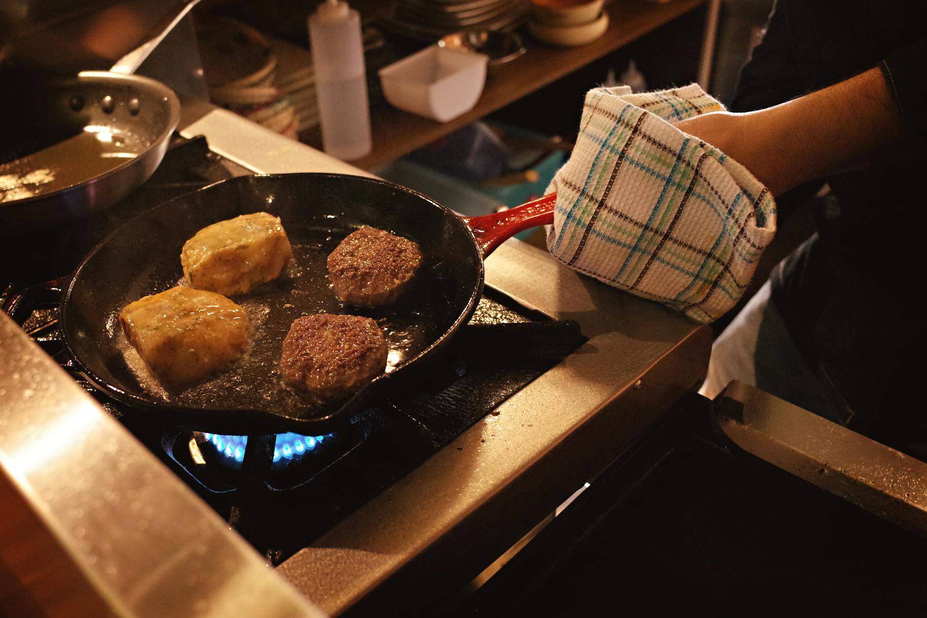 Burgery i kotlety z indyka smażące się na patelni na kuchence