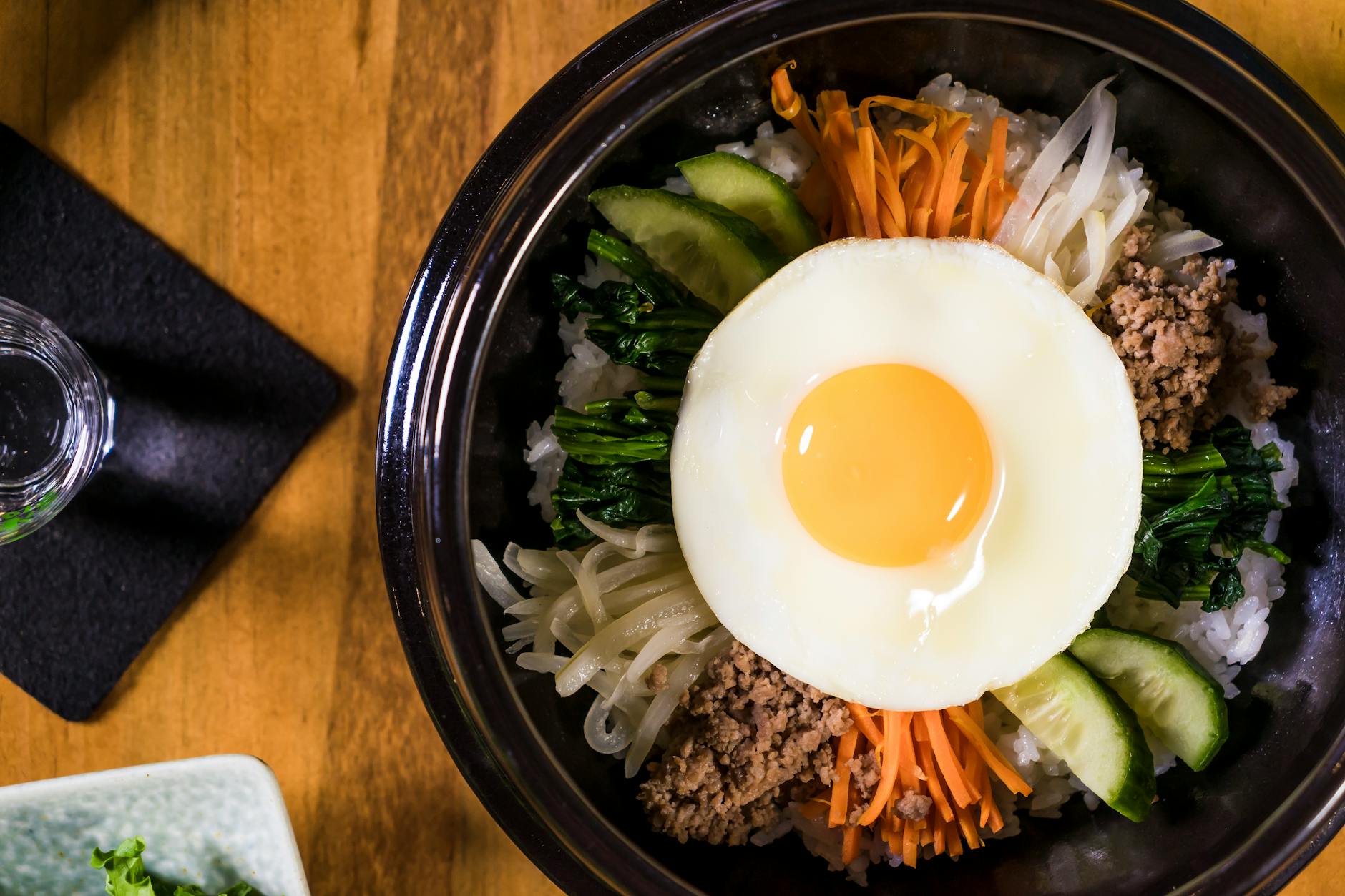 Bibimbap w misce z wołowiną, smażonym jajkiem i kolorowymi warzywami