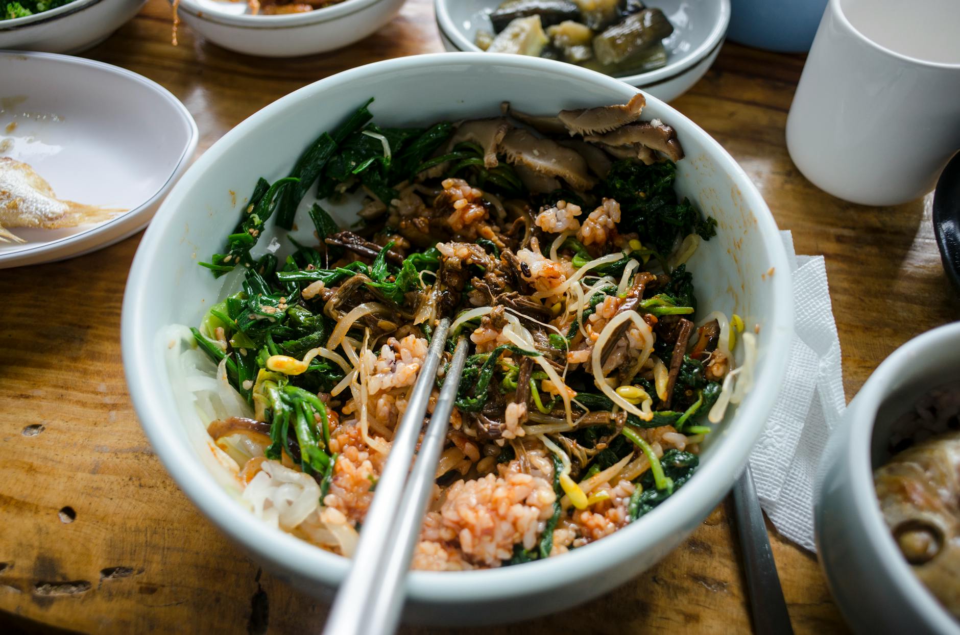 Kolorowa miska koreańskiego bibimbapu z warzywami, ryżem i grzybami