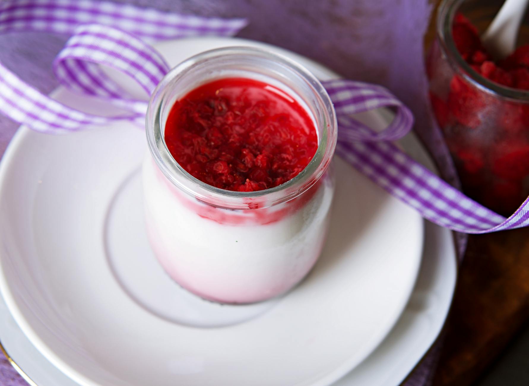 Panna cotta waniliowa w słoiczku z sosem malinowym i świeżymi malinami