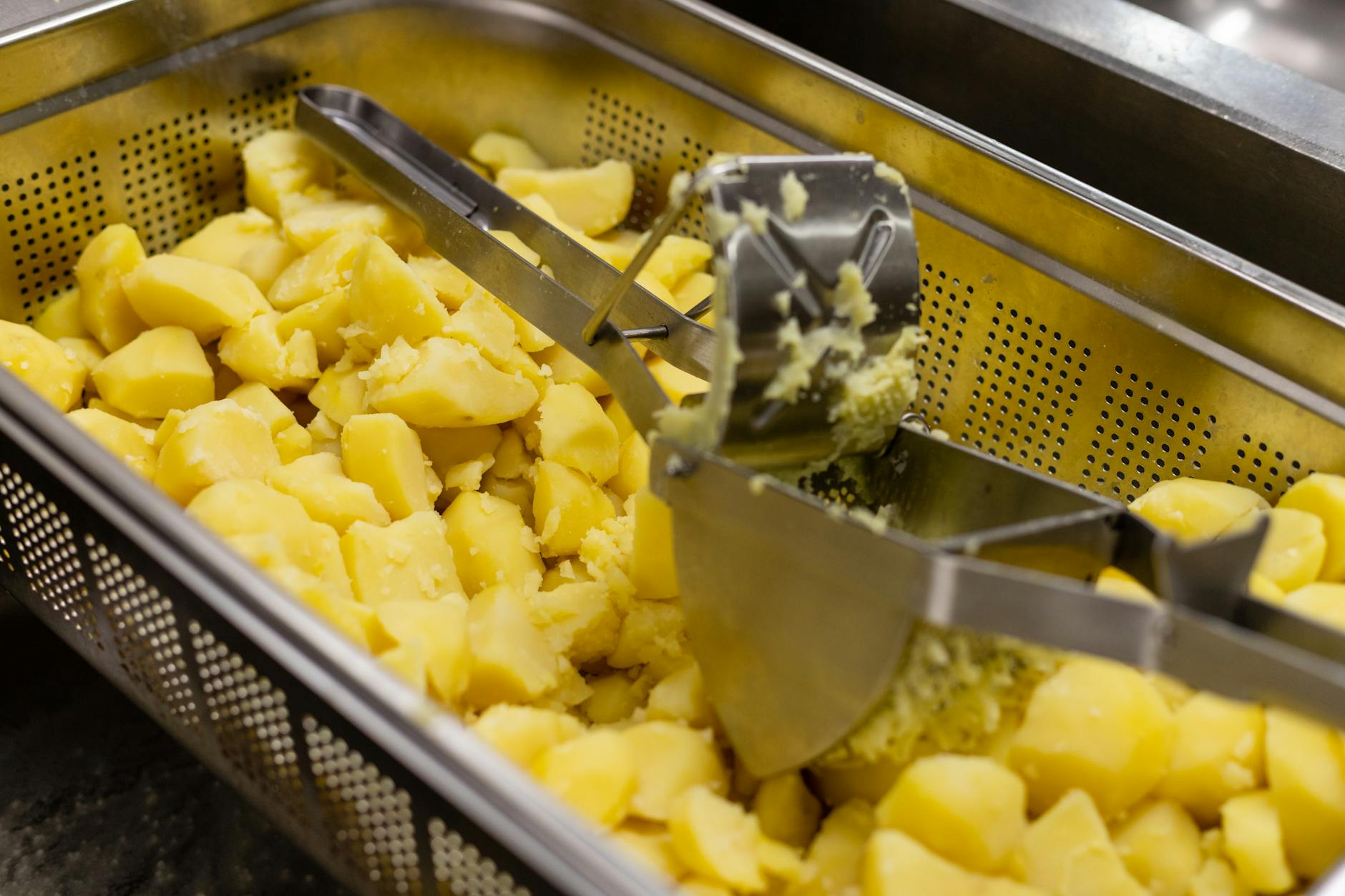 Tłuczenie gorących ziemniaków na puree w profesjonalnej kuchni