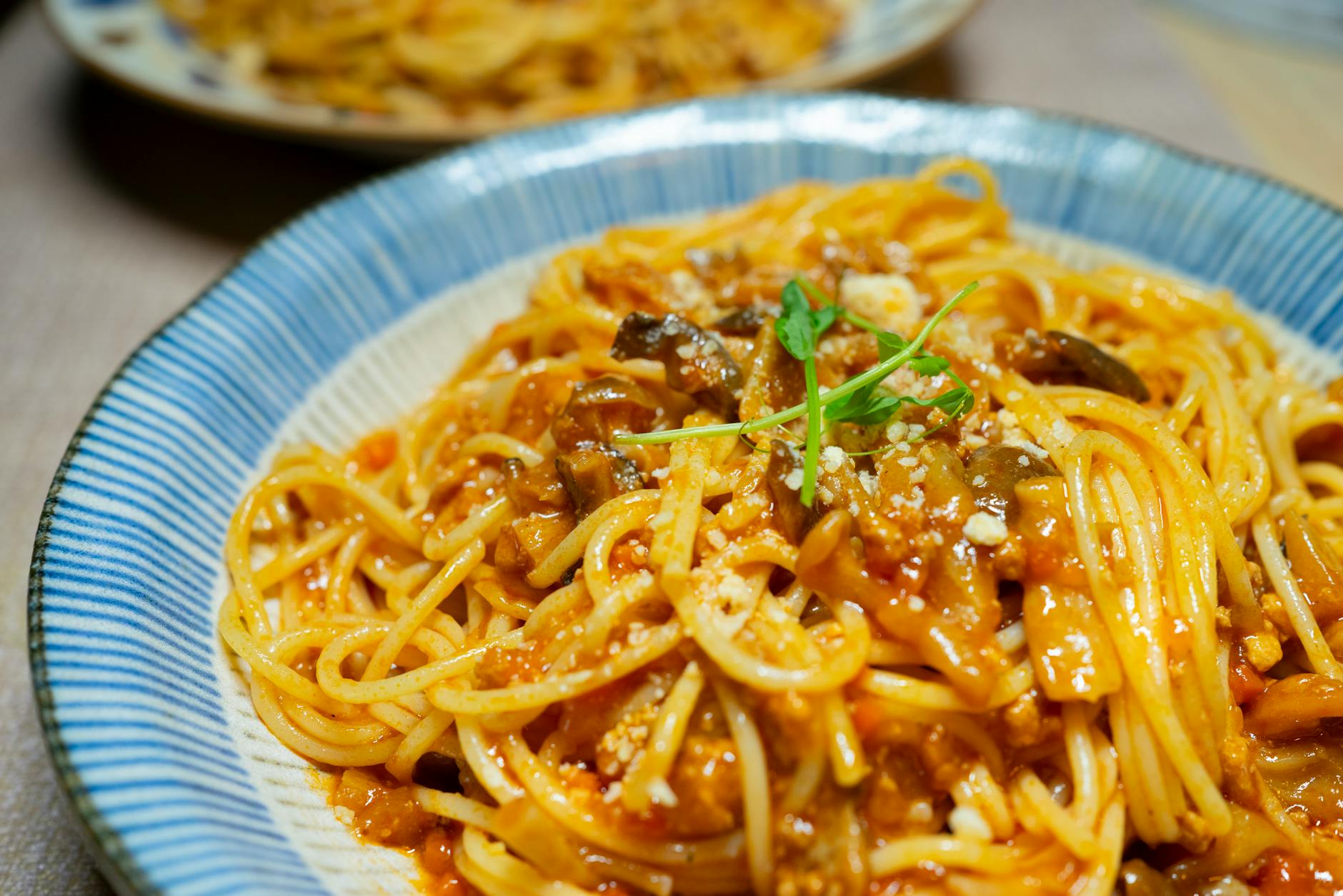 Makaron spaghetti w sosie pomidorowym z pieczarkami i ziołami z bliska