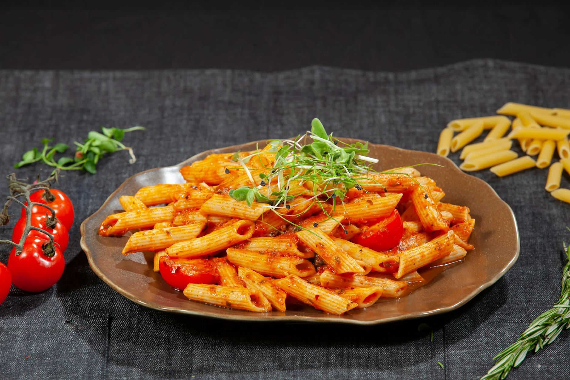 Talerz makaronu penne z sosem pomidorowym, czosnkiem i świeżą bazylią